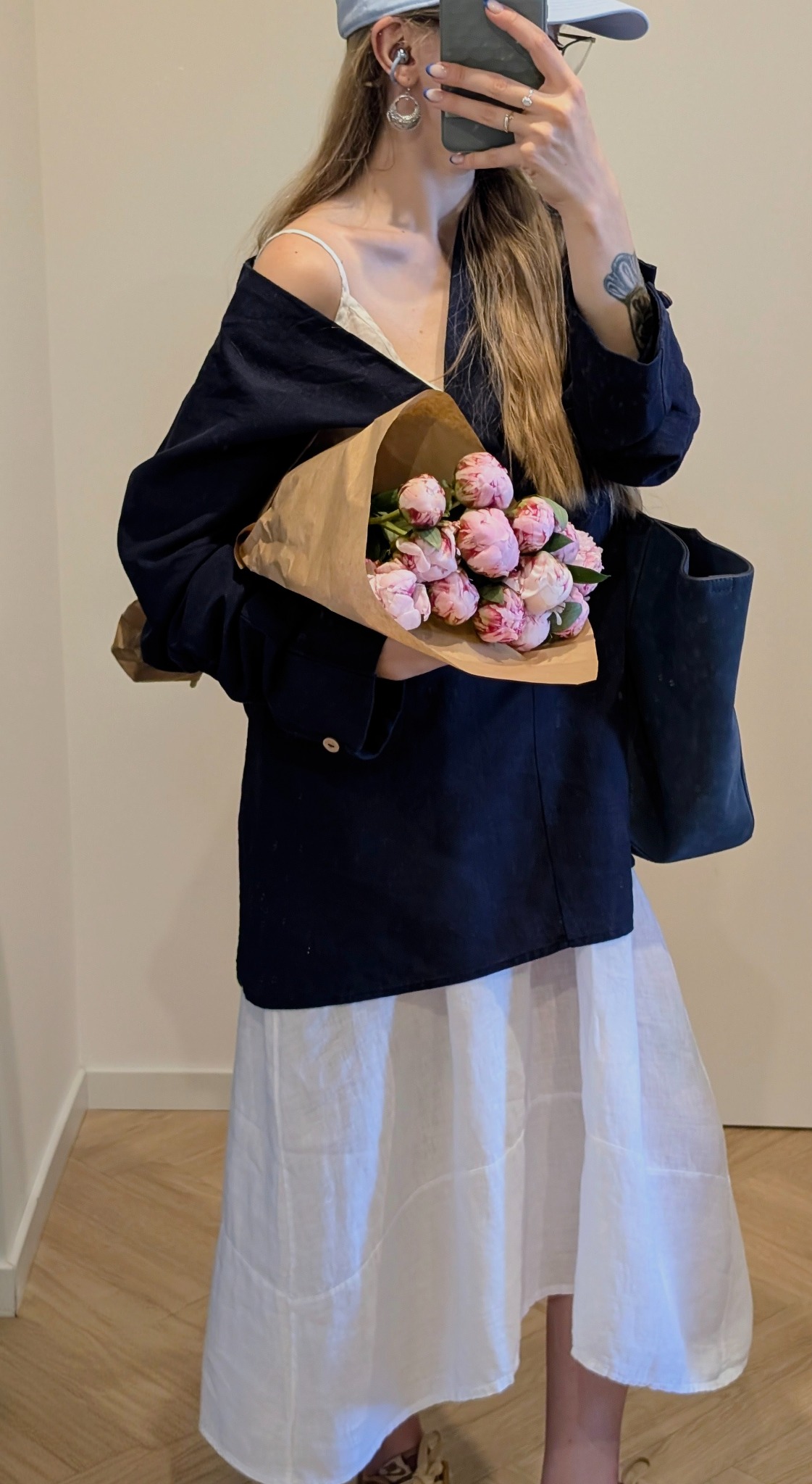 Vero holding a bouquet of pink flowers in a mirror